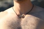 Hombre usando un colgante de cuero con perlas negras de Tahití
