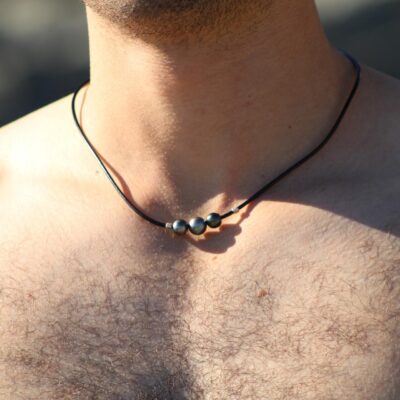 Hombre usando un colgante de cuero con perlas negras de Tahití