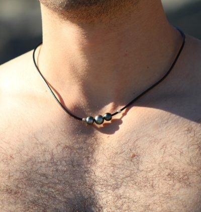 Hombre usando un colgante de cuero con perlas negras de Tahití
