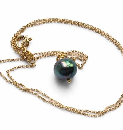 Colgante con cadena dorada y perla negra de Tahití sobre fondo blanco